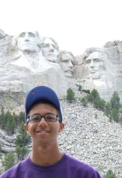 Boy named Damaris standing below Mt. Rushmore