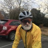 gray bearded cyclist in a yellow windbreaker