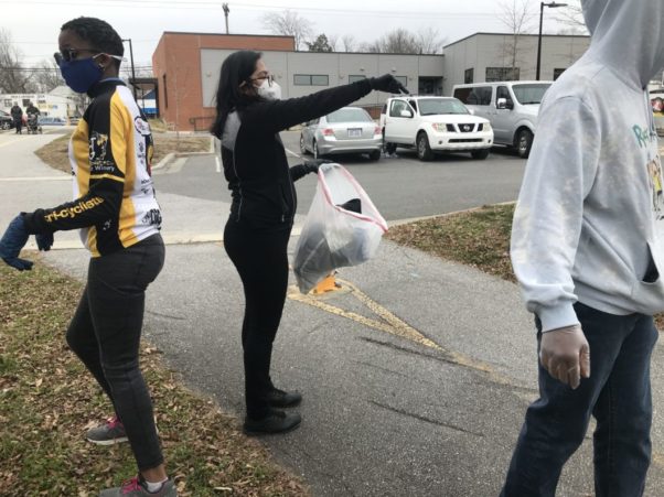 Program Manager, Itza, directing Triangle Bikeworks youth while a young girl and boy move to pick up trash along the Libba Cotten trail